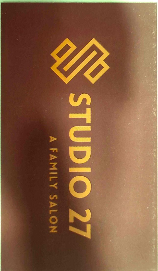 Gold Studio 27 A Family Salon lettering on a brown wall